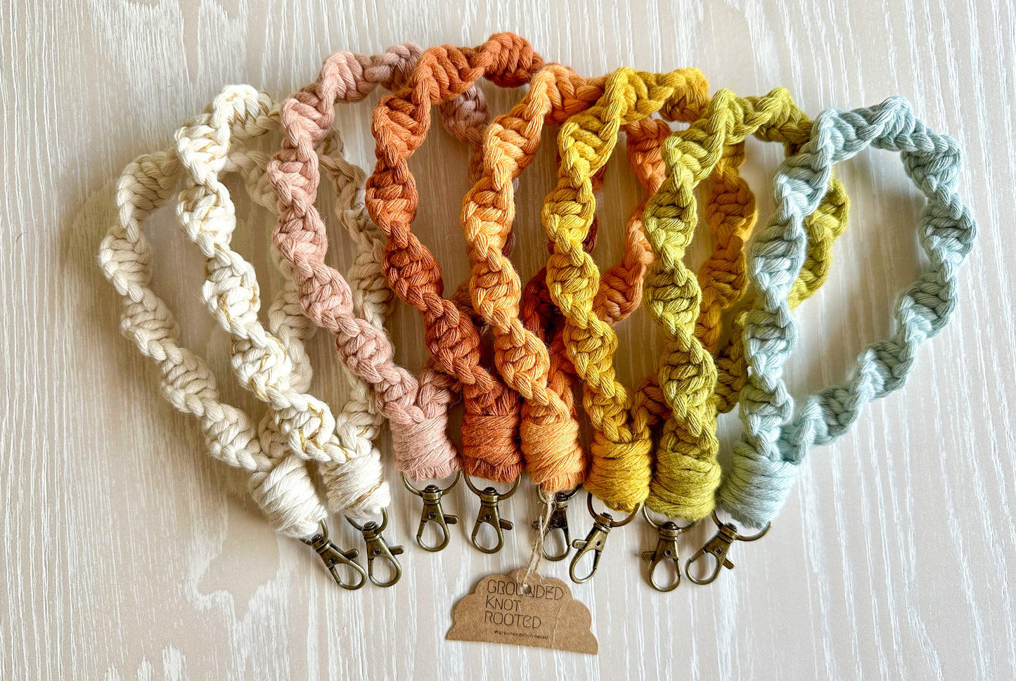 Set of colorful knitted keychains on a light wooden surface