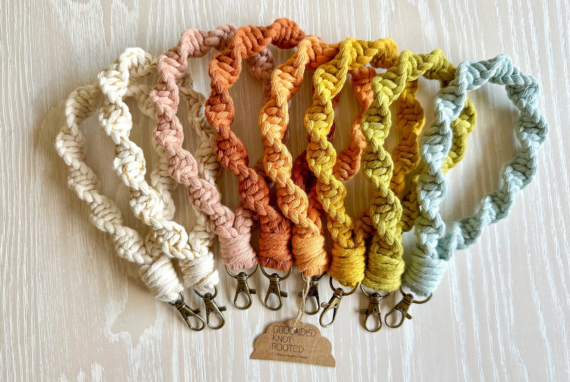 Set of colorful knitted keychains on a light wooden surface